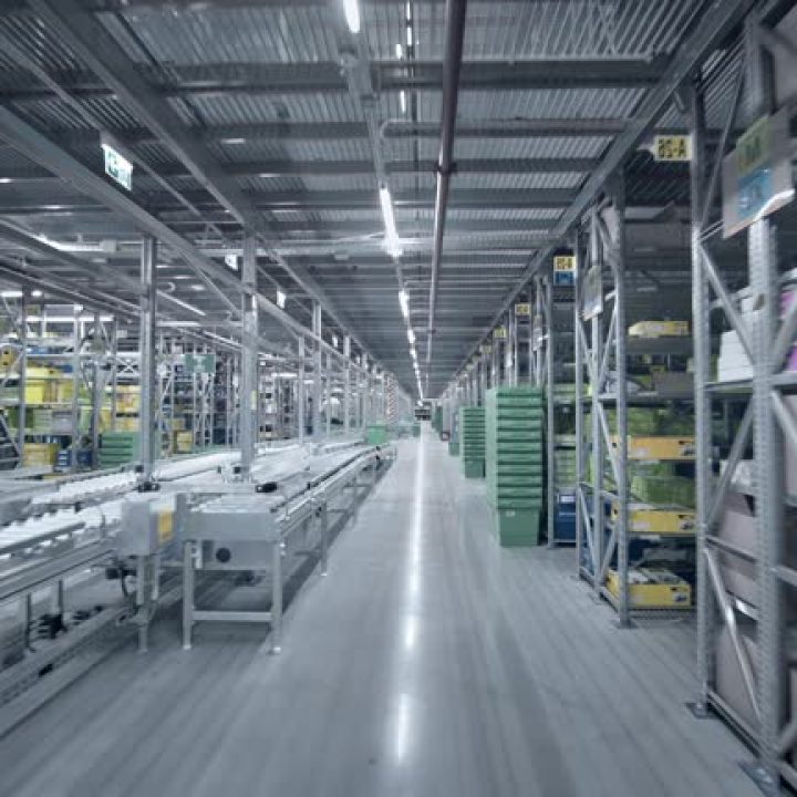 Camera pan of empty storage building. Multiple empty racks. Warehouse or a factory interior